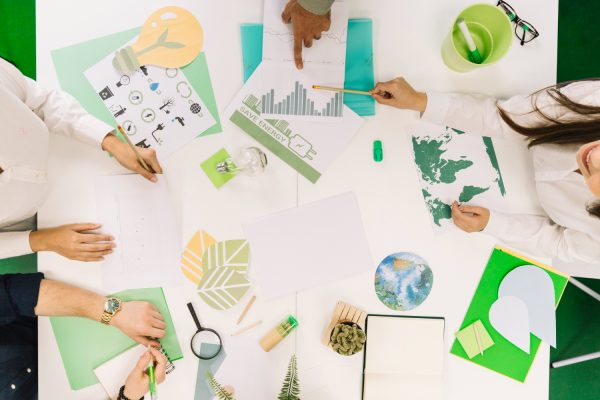businesspeople-working-graph-with-various-natural-resources-icon-desk